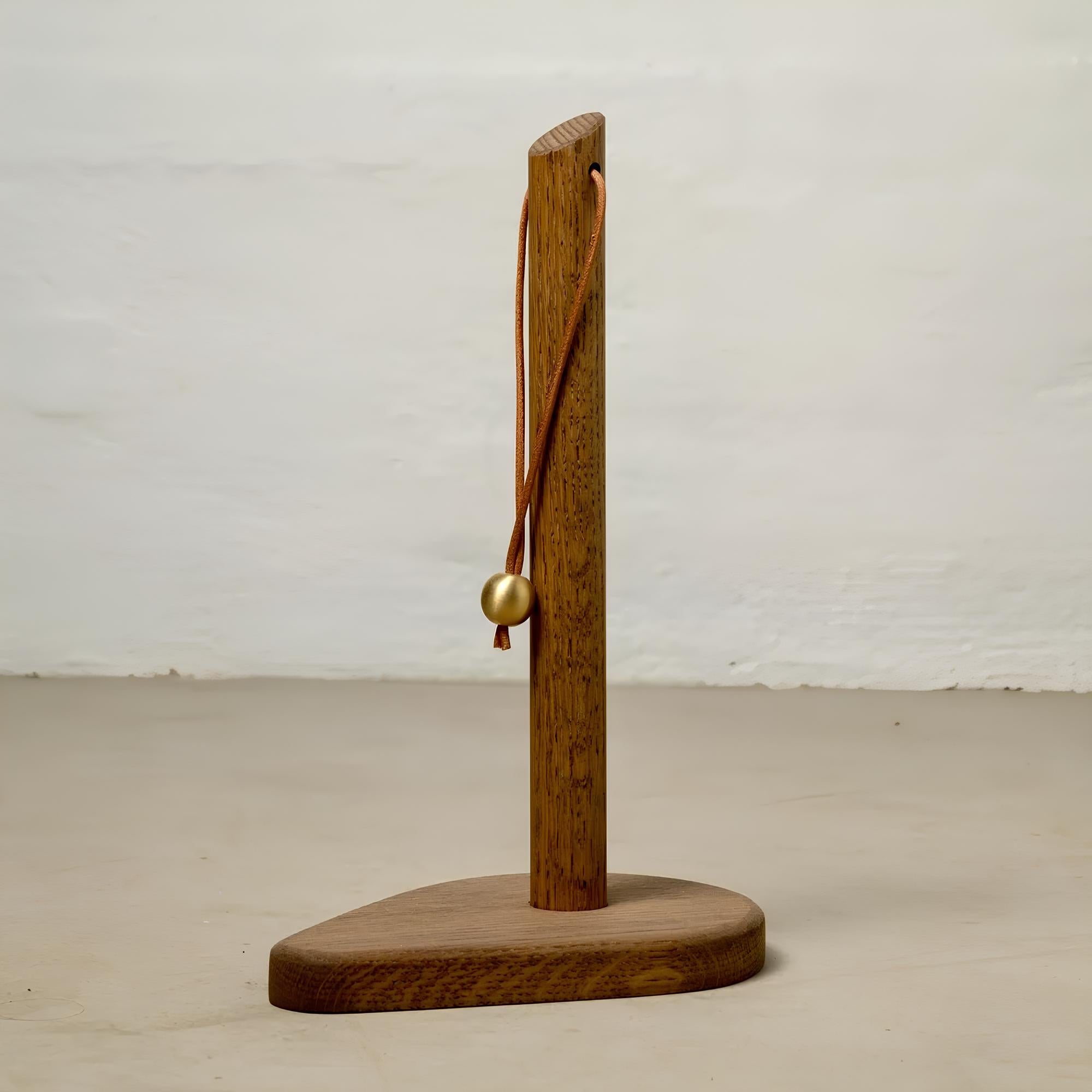 Porte-rouleau de cuisine « Le Cygne » – chêne massif, cuir et laiton.